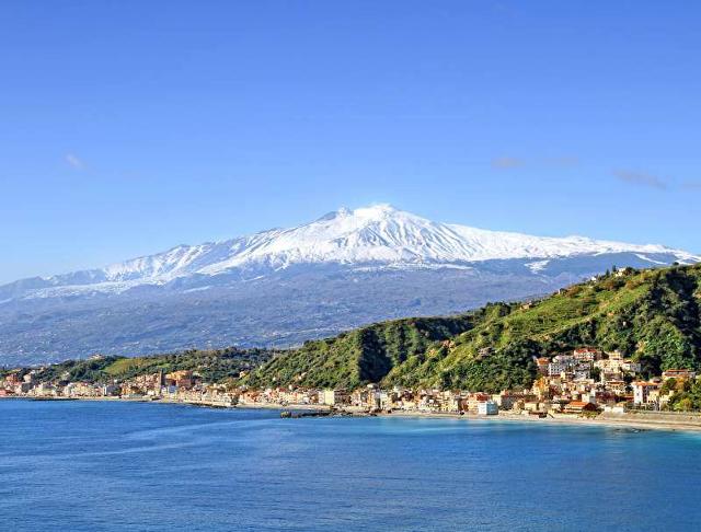 Un panorama della costa di Taormina con lo sfondo dell'Etna Un panorama della costa di Taormina con lo sfondo dell'Etna
